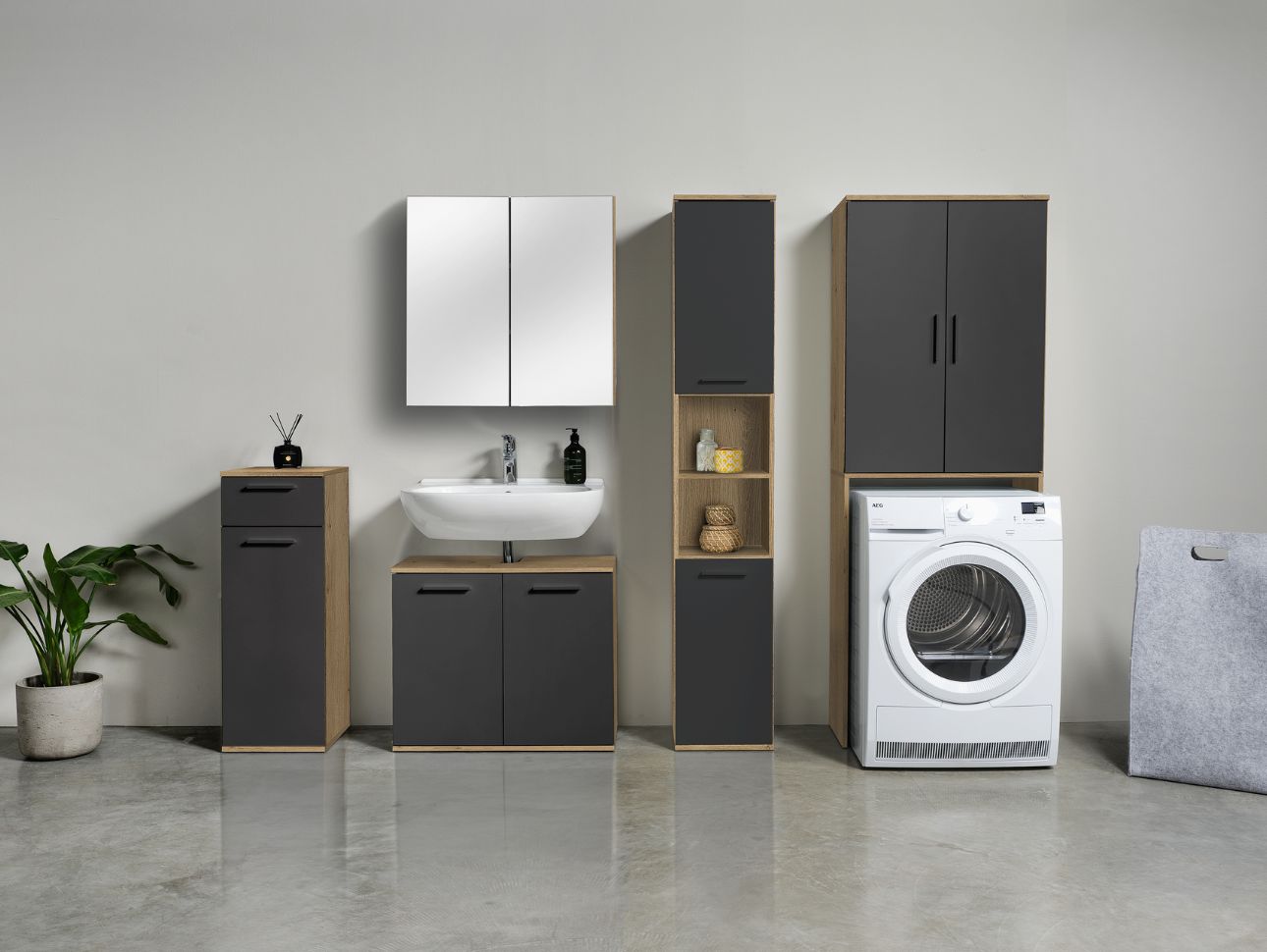 Badschränke in eiche und anthrazit nebeneinander an einer Wand,  kleiner Badschrank, Waschbecken Unterschrank, Spiegelschrank, Badhochschrank und Waschmaschinenschrank 