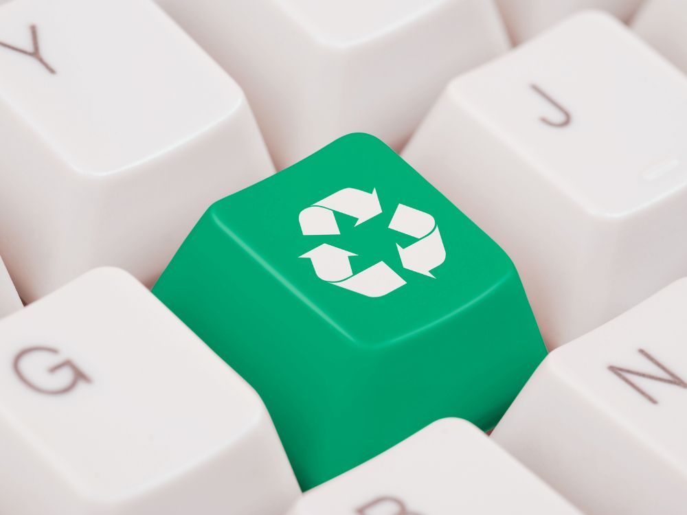 tasten einer Tastatur, eine Taste ist grün mit einem weißen Recycling Symbol drauf 